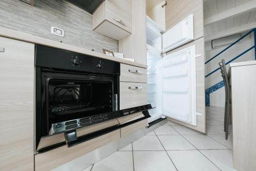 a kitchen with a black oven and a refrigerator at Gioema in Borgo Vodice