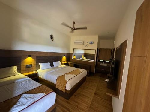a hotel room with two beds and a flat screen tv at Park View Yelagiri in Yelagiri