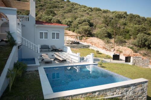 een villa met een zwembad en een huis bij luxurylefkadavilla in Vasiliki