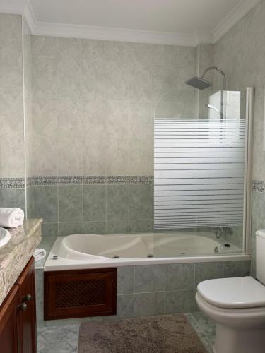 a bathroom with a tub and a toilet and a sink at Habitacion 801 in Estepona