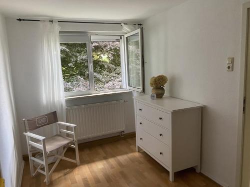 1 dormitorio con vestidor, silla y ventana en NEU! Moderne Fewo Schieke, en Schleiz