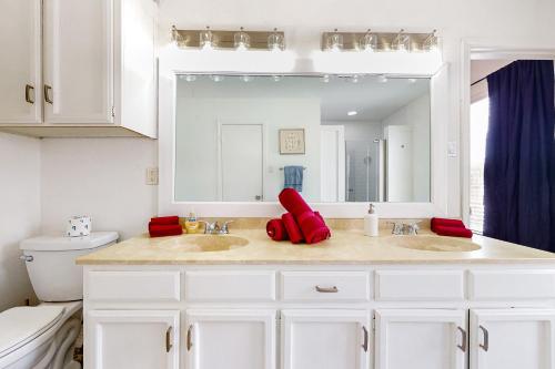 a white bathroom with two sinks and a mirror at Peachtree in Round Rock