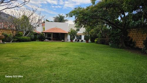 a yard of a house with a grass field at Casa de 1 nivel con alberca en fraccionamiento las Fincas. in Jiutepec