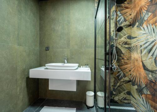 a bathroom with a sink and a glass shower at La Veranda Villas in Kumluca