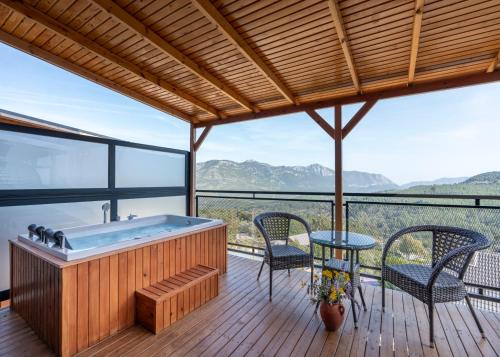 a hot tub on a deck with a table and chairs at La Veranda Villas in Kumluca