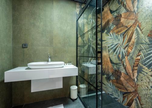 a bathroom with a sink and a glass shower at La Veranda Villas in Kumluca