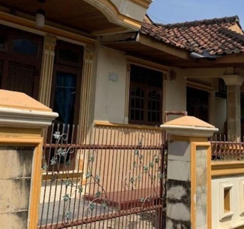 une maison avec une clôture devant elle dans l'établissement Bintang Property, à Kedaton