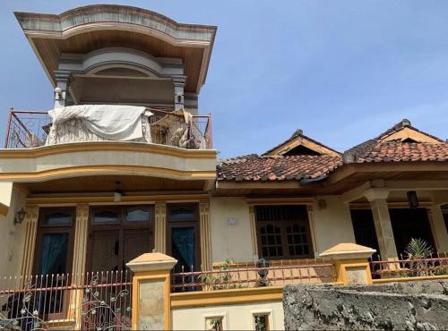 une maison avec un balcon avec un chien sur le balcon dans l'établissement Bintang Property, à Kedaton