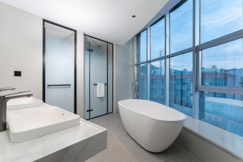 a bathroom with a white tub and a large window at Holiday Inn Express Shangri-La by IHG in Shangri-La
