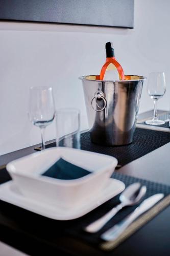 a table with a plate and a bottle of wine in a bucket at Apartament Sztuk Pięknych 4 in Piła