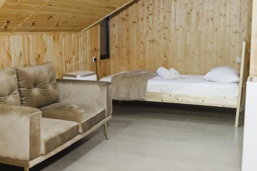a bedroom with a bed and a couch and a chair at Dom Adonis in Dilijan