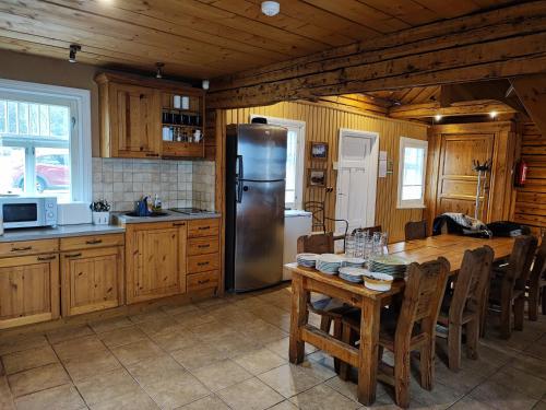 a kitchen with a table and a stainless steel refrigerator at Lainela puhkeküla in Käsmu