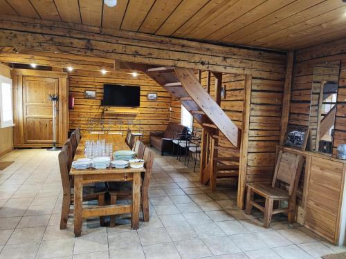 - une salle à manger avec une table, des chaises et une télévision dans l'établissement Lainela puhkeküla, à Käsmu