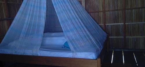 a bed with a mosquito net on top of it at Nyanse Homestay - Raja Ampat in Besir