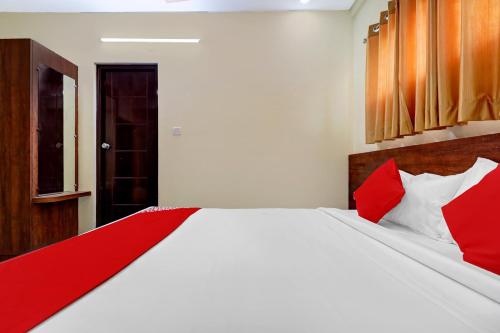 - une chambre avec une couverture rouge sur un lit blanc dans l'établissement Super OYO Hotel Silver House Near Mantri Square Mall, à Bangalore