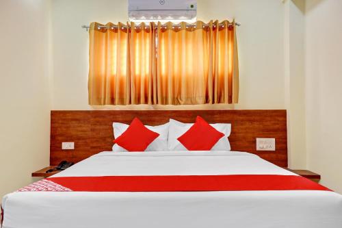 - une chambre avec un grand lit et des oreillers rouges dans l'établissement Super OYO Hotel Silver House Near Mantri Square Mall, à Bangalore