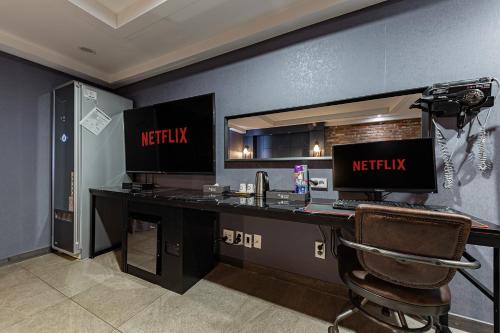 a desk with two computer monitors on top of it at Hotel Soseol Smith in Cheonan