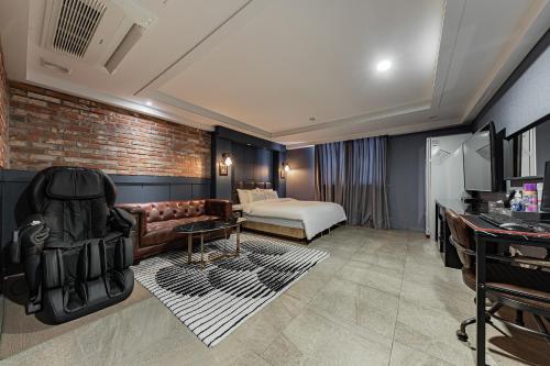 a hotel room with a couch and a bed at Hotel Soseol Smith in Cheonan