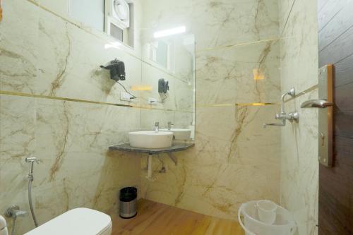 uma casa de banho com um lavatório e um WC em Airport Grand Travel Inn em Nova Deli