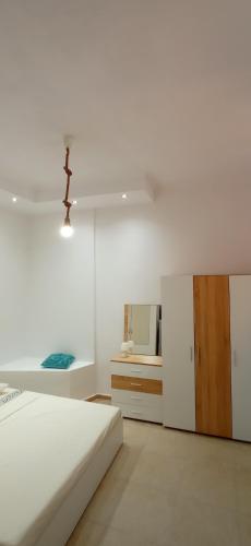 Habitación blanca con cama y espejo en Karnayo Bay apartment, en Kavala
