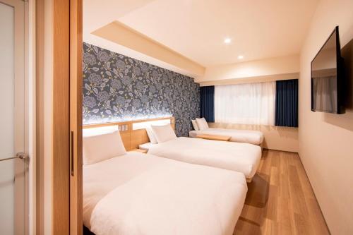 東京的住宿－唐草飯店東京站，酒店客房设有两张床和电视。