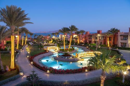 a resort with a large swimming pool at night at Charmillion Sea Life Resort in Sharm El Sheikh