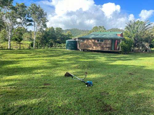 a yard with a house and a lawn mower in the grass at Farnborough Stay in Yeppoon