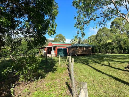 a barn in a field next to a fence at Farnborough Stay in Yeppoon