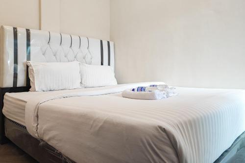 1 dormitorio con 1 cama blanca grande con sábanas blancas en RedDoorz Syariah near Transmart Jambi, en Palmerah