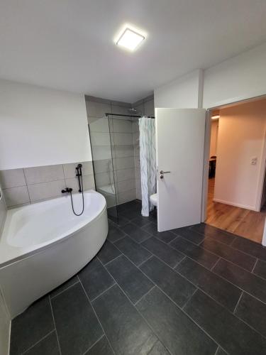 a bathroom with a bath tub and a shower at Life Zone 11 in Molbergen