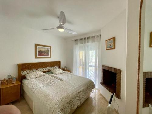 1 dormitorio con 1 cama y ventilador de techo en Comfy apartment in the heart of the Costa del Sol, en Mijas Costa