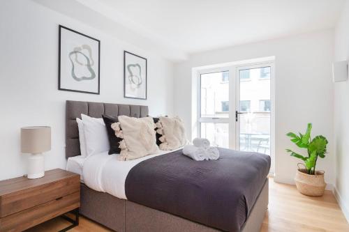 a bedroom with a bed with a teddy bear on it at Soho & Fitzrovia with Balcony - CityApartmentStay in London