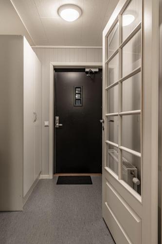 a hallway with a black door in a room at Longyearbyen Apartment in Longyearbyen