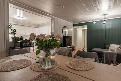 un jarrón de flores sobre una mesa en la sala de estar en Longyearbyen Apartment, en Longyearbyen
