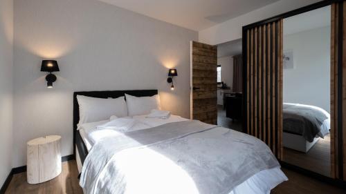 a bedroom with a large white bed and a mirror at Szkolna, Sun & Snow in Szczyrk