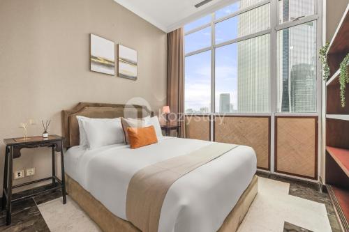 a bedroom with a large bed and a large window at Soka by Kozystay - Mega Kuningan in Jakarta