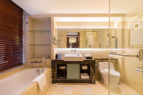 a bathroom with a tub and a sink and a toilet at Beijing Pudi Hotel in Beijing