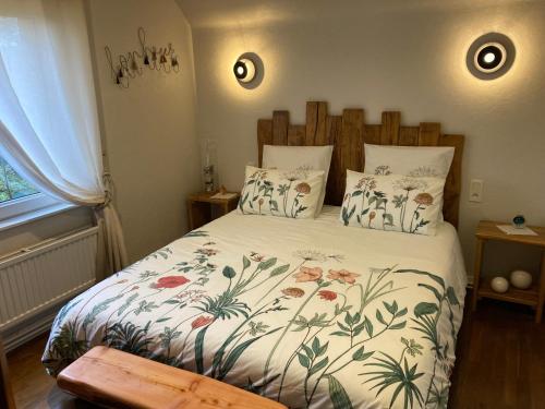 1 dormitorio con 1 cama con colcha de flores en Les Chambres de Kermenguy, en Sibiril