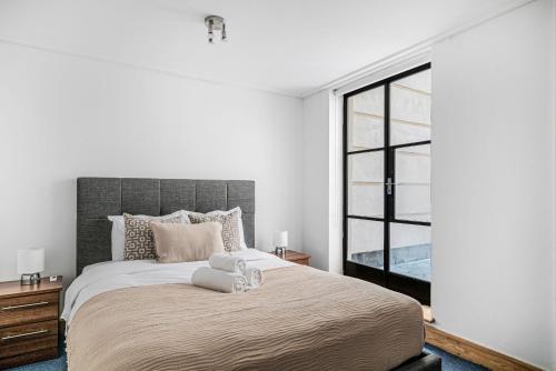 ein Schlafzimmer mit einem großen Bett und einem großen Fenster in der Unterkunft Heart of Holborn with Patio - CityApartmentStay in London