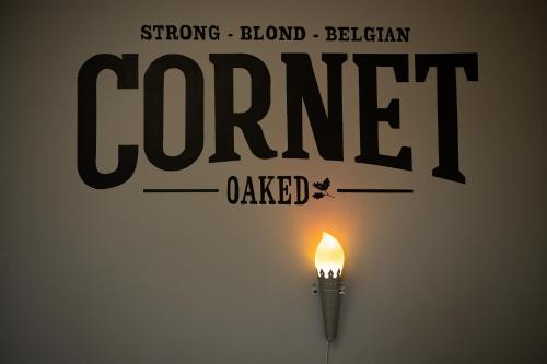 a candle on a wall with the words corner called at Appartementen The Place 2 Beer in Bullange