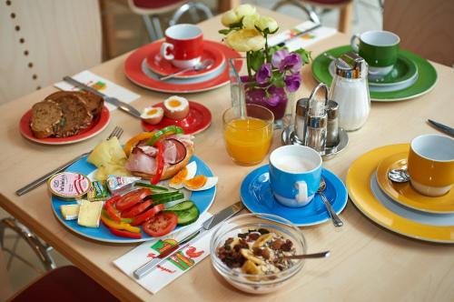 einen Tisch mit Teller mit Speisen und Tassen Kaffee in der Unterkunft Hotel Kolping Wien Zentral in Wien