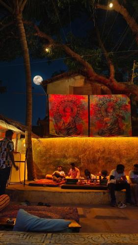 a group of people sitting on a bench at night at Mitra Hostel in Arambol