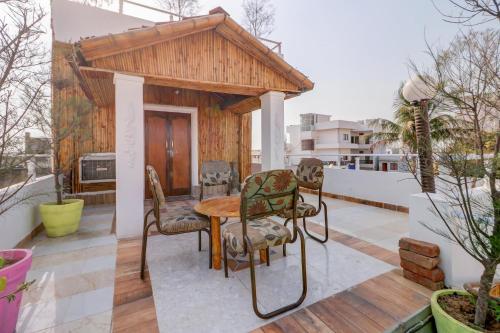 a patio with a table and chairs on a balcony at Hotel O Shanti Kuti Home Stay in Lucknow
