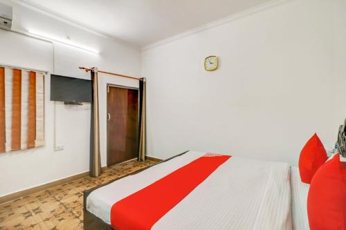 a bedroom with a red and white bed and a window at Hotel O Shanti Kuti Home Stay in Lucknow