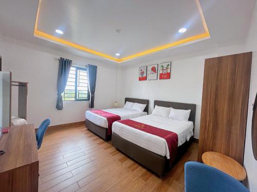 a hotel room with two beds and a desk at Apple Hotel in Can Tho