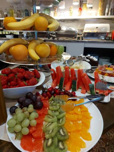 a buffet of fruits and vegetables on plates on a table at Best Boutique Hotel in Stara Zagora