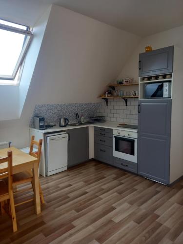 a kitchen with gray appliances and a wooden table at Chalupa U Kravína in Rtyně v Podkrkonoší
