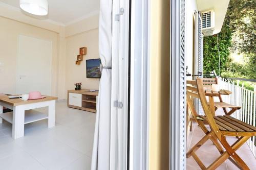 Habitación con balcón con silla y mesa. en Areti's Home! en Agios Rokkos