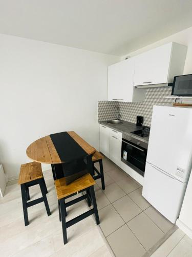uma cozinha com uma mesa de madeira e um frigorífico em Studio 2 pers, Villemomble disneyland Porte de la villette em Villemomble