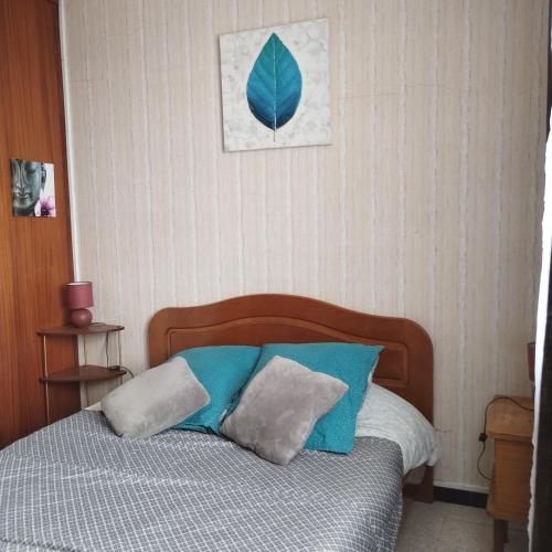 een slaapkamer met een bed met blauwe kussens bij Appartement T2 près de la mer in Canet-en-Roussillon
